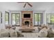 Bright living room featuring a stone fireplace, TV, hardwood floors, and sliding doors to the outdoor balcony at 5504 Spring Bluffs Ln, Raleigh, NC 27606