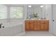Elegant bathroom with soaking tub, double vanity, and large window at 5504 Spring Bluffs Ln, Raleigh, NC 27606