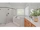 Bright bathroom featuring a glass shower and soaking tub with a large window at 5504 Spring Bluffs Ln, Raleigh, NC 27606