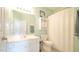 Well-lit bathroom with a toilet, mirror, sink, and shower with shower curtain at 5901 Chivalry Ct, Raleigh, NC 27612