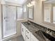 Modern bathroom with a glass-enclosed shower and dual sinks with black marble countertops at 6245 Reagan Ln, Wake Forest, NC 27587