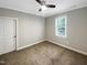 Empty bedroom with a ceiling fan, a window, light walls and neutral carpeting at 6245 Reagan Ln, Wake Forest, NC 27587