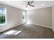 Neutral carpeted bedroom featuring natural light from two windows and a ceiling fan at 6245 Reagan Ln, Wake Forest, NC 27587