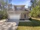 Charming two-story home featuring a gray facade, white garage door, and landscaped front yard at 6245 Reagan Ln, Wake Forest, NC 27587