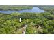 Aerial view showcasing a home on a wooded lot near a beautiful lake at 6614 Chantilley Place, Bahama, NC 27503