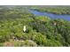 Breathtaking aerial view showcasing a property nestled amidst lush greenery and a serene lake at 6614 Chantilley Place, Bahama, NC 27503