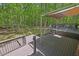 Multi-tiered deck overlooks expansive wooded yard with mature trees and lush landscaping at 6614 Chantilley Place, Bahama, NC 27503