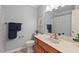 Well-lit bathroom with a vanity, large mirror, and fresh blue paint, providing a relaxing atmosphere at 6614 Chantilley Place, Bahama, NC 27503