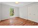 Clean bedroom with wood floors, natural light, a closet, and neutral paint, ready for personalization at 6614 Chantilley Place, Bahama, NC 27503