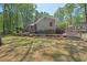 Rear exterior of home with spacious deck, mature trees, and attractive landscaping at 6614 Chantilley Place, Bahama, NC 27503