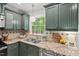 Charming kitchen featuring a stainless steel sink overlooking lush greenery at 6614 Chantilley Place, Bahama, NC 27503