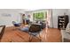 Bright living room featuring hardwood floors, neutral walls, and a large window providing natural light at 6614 Chantilley Place, Bahama, NC 27503