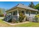 Charming exterior featuring a covered porch, well-kept lawn, and beautiful landscaping at 7308 York, Mebane, NC 27302