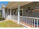 Inviting front porch with white railings and outdoor seating, perfect for relaxing and enjoying the outdoors at 7308 York, Mebane, NC 27302