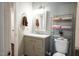 Renovated bathroom with gray vanity, updated fixtures, and convenient shelving at 861 Dalewood Dr, Raleigh, NC 27610