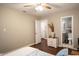 Cozy bedroom features wood floors, ceiling fan, and neutral paint; bathroom through doorway at 861 Dalewood Dr, Raleigh, NC 27610