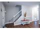 Entryway featuring dark floors, a staircase, accent table, and a view to the front door at 861 Dalewood Dr, Raleigh, NC 27610