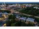 An aerial nighttime view of townhouses, a baseball field, trees, and city buildings with lights at 1012 Manor Way, Durham, NC 27701