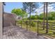 View of a wood balcony with metal railings, trees, and grass at 1012 Manor Way, Durham, NC 27701