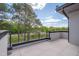 A modern balcony features tiled flooring and a sleek black railing with a lush, green treeline view at 1012 Manor Way, Durham, NC 27701
