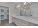 Modern bathroom with double vanity, large mirror, and access to a walk-in closet and tiled shower at 1012 Manor Way, Durham, NC 27701
