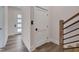 Bright hallway featuring a modern front door, wooden floors and staircase at 1012 Manor Way, Durham, NC 27701