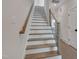 Modern staircase with wooden steps, sleek metal railing, and neutral decor at 1012 Manor Way, Durham, NC 27701