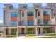 Modern townhomes showcasing a brick facade, balconies, and sleek black metal railings at 1012 Manor Way, Durham, NC 27701