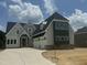 New construction shows a two-story home with a three-car garage and a combination of siding and brick exterior at 1021 Azalea Garden Cir, Raleigh, NC 27603