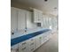 The kitchen has white cabinets, drawers, and a blue countertop cover at 1021 Azalea Garden Cir, Raleigh, NC 27603