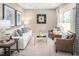 Bright living room features large windows, comfortable seating, and sophisticated decor with a neutral color palette at 1044 Country Pasture Cv, Wendell, NC 27591