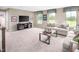 Spacious living room with modern sofas, large windows, and television at 1044 Country Pasture Cv, Wendell, NC 27591