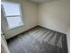 Bright bedroom featuring large window and plush carpeting at 10527 Brookside Reserve Rd, Raleigh, NC 27614