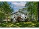 A fenced backyard featuring a white cottage-style home, a green lawn, and mature landscaping at 107 Piquot Dr, Louisburg, NC 27549