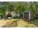 A backyard featuring a lush green lawn, a small shed, and a well-maintained home exterior at 107 Piquot Dr, Louisburg, NC 27549