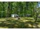 Spacious backyard featuring lush greenery, trees, sheds and fire pit perfect for outdoor enjoyment at 107 Piquot Dr, Louisburg, NC 27549