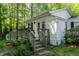 Wooden deck and fenced-in yard of the white cottage-style home, accented by trees at 107 Piquot Dr, Louisburg, NC 27549