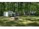 Spacious backyard featuring lush greenery, trees, sheds and fire pit perfect for outdoor enjoyment at 107 Piquot Dr, Louisburg, NC 27549