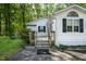 Close-up of the front entry, showcasing the wooden deck, well-kept siding, and greenery at 107 Piquot Dr, Louisburg, NC 27549
