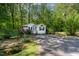 Cozy white cottage-style home surrounded by trees, featuring a well-manicured lawn at 107 Piquot Dr, Louisburg, NC 27549