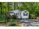 Charming cottage-style home with mature trees, a well-manicured lawn, and vibrant flowers at 107 Piquot Dr, Louisburg, NC 27549