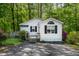 Charming cottage-style home with white siding, black shutters, and mature landscaping at 107 Piquot Dr, Louisburg, NC 27549