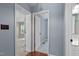 Hallway with doorways to a bedroom and a bathroom, featuring neutral walls and wood floors at 107 Piquot Dr, Louisburg, NC 27549