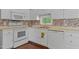 This charming kitchen offers ample counter space, stainless sink, tiled backsplash, and modern appliances at 107 Piquot Dr, Louisburg, NC 27549