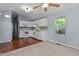 The kitchen features white cabinets, stainless appliances, hardwood floors, a window, and grey walls at 107 Piquot Dr, Louisburg, NC 27549