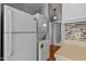 Efficient laundry area with stacked washer and dryer, and adjacent refrigerator, seamlessly integrated into the kitchen space at 107 Piquot Dr, Louisburg, NC 27549