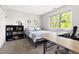 Well-lit bedroom with a desk, bookcase, and carpet, ideal for relaxation and focused work or study at 109 Bessemer Pl, Durham, NC 27712