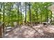 Expansive deck area surrounded by lush trees, offering an outdoor dining set and serene outdoor space at 109 Bessemer Pl, Durham, NC 27712