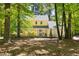 Inviting yellow home with a covered front porch surrounded by trees at 109 Bessemer Pl, Durham, NC 27712