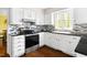 Sunlit kitchen with stainless steel appliances, black granite countertops, and white cabinetry with a view from the window at 109 Bessemer Pl, Durham, NC 27712